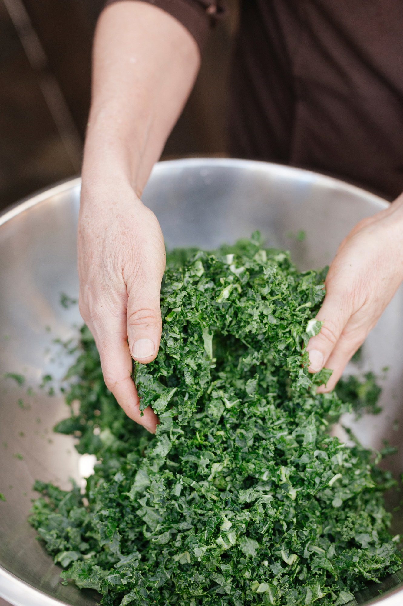 chef-hands-tossing-kale-salad